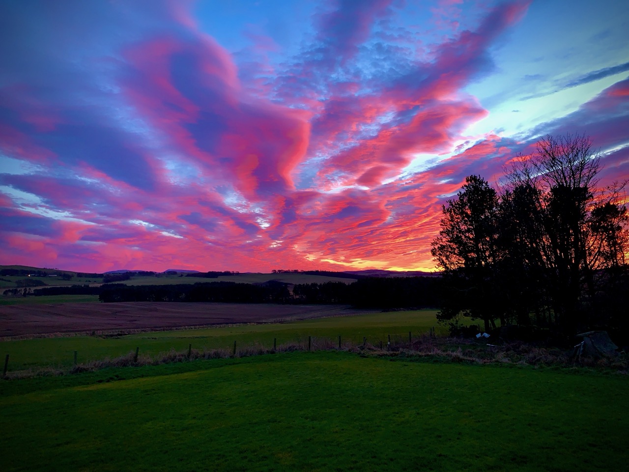Dramatic pink and purple sunset over the fields around Dunsyre with sweeping cloud formations